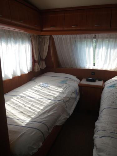 毛焦尔海尔泰伦德Forrás camping的小房间设有床和2个窗户