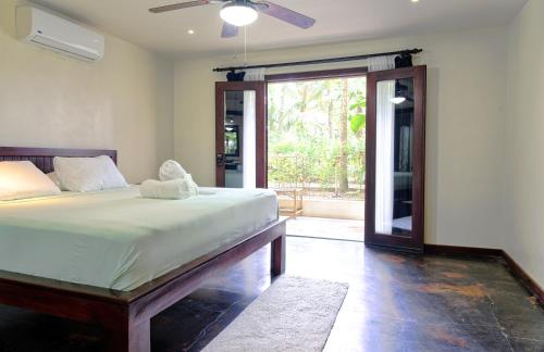 多米尼克Hona Beach Hotel的一间卧室设有一张床和一个滑动玻璃门