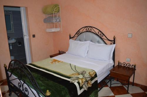 马拉喀什Hotel salem leksor的一间卧室配有一张带白色床罩的床