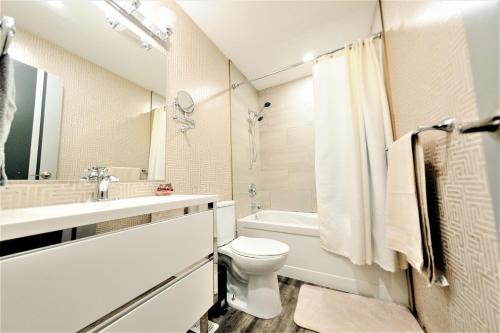 温尼伯The Modern Spot的白色的浴室设有卫生间和水槽。