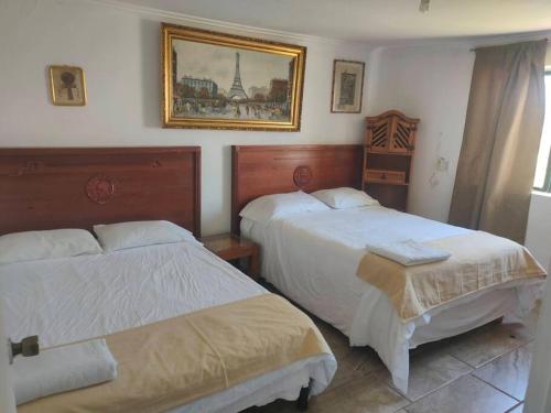 CuauhtémocBeautiful Rustic Cottage Adobe, Rancho El Payasito的卧室配有两张床,墙上挂着一幅画