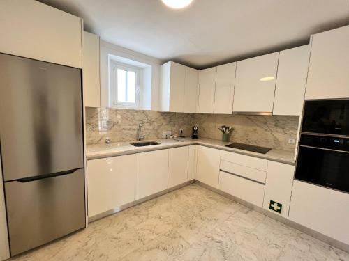 埃武拉Madre de Deus, 5 - Terrace的厨房配有白色橱柜和不锈钢冰箱