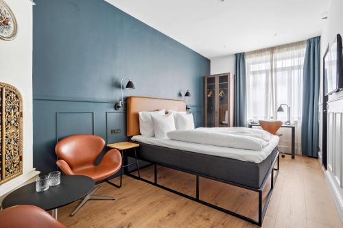 哥本哈根The Huxley Copenhagen, BW Premier Collection的配有一张床和一把椅子的酒店客房