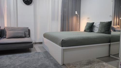 海法Studio Apartment 12 Minutes from Bahai's garden的一间卧室配有一张床和一张沙发