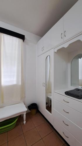 苏瓦Mead Road Homestay Tours & Transfers Deluxe Flat 2 Bedroom的厨房配有白色橱柜和镜子