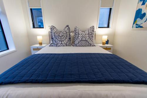 基督城Luxurious 2 bedroom Retreat的一间卧室配有一张带蓝色棉被和窗户的大床