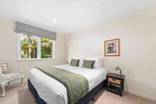 陶波Great Lake Getaway - Taupo的卧室配有床、椅子和窗户。