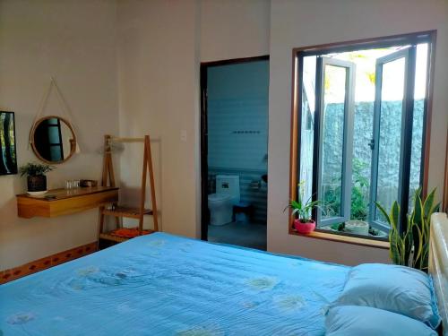 Gia NghĩaLy's homestay的一间卧室设有蓝色的床和窗户。