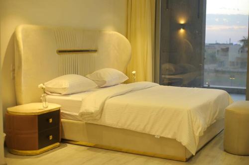 Sheikh Zayedقصر السفير بيفرهيلز的卧室配有白色的床和窗户。