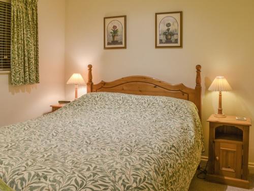 North MundhamHoneysuckle Cottage的一间卧室配有一张床和两张台灯。