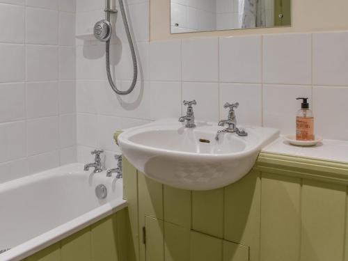North MundhamHoneysuckle Cottage的浴室配有盥洗盆和浴缸。