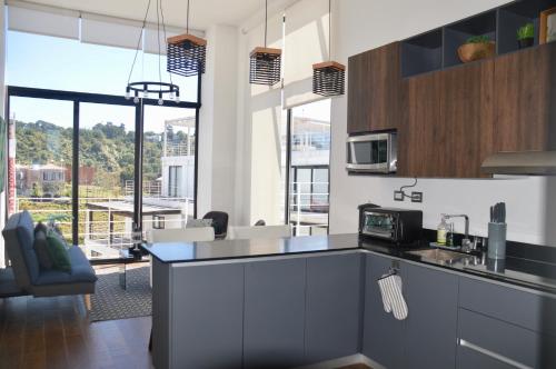 危地马拉Cozy Stays Cayala Apartments 602的厨房设有微波炉的柜台