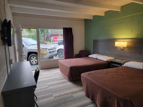 温特黑文Budget Inn Winter Haven Auburndale的酒店客房设有两张床和一个停车位。