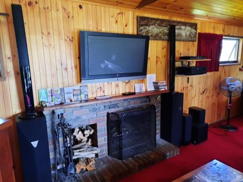芬戈The Beach Cabin的客厅设有壁炉和平面电视
