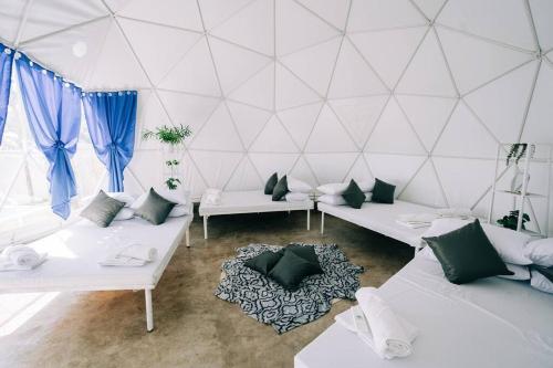 LuboFamily Dome Glamping in Rizal with Private Hotspring的一间设有白色沙发和蓝色窗帘的客房