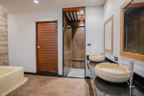 普吉镇Malabar Pool Villa Phuket的浴室配有2个盥洗盆和1个浴缸。