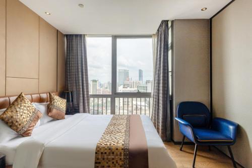 广州优优国际公寓（广州市越秀区北京路捷登都会店）的酒店的客房 - 带一张床、椅子和窗户
