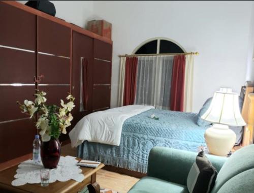 Tendean's Homestay in Tampusu的一间卧室配有一张床、一张沙发和一张桌子