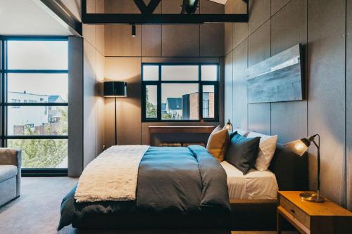 吉斯伯恩Mews Cottages的一间卧室设有一张床和两个窗户。