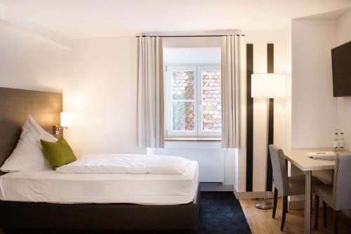因戈尔施塔特MO Hotel by WMM Hotels的一间卧室配有一张床、一张书桌和一个窗户。