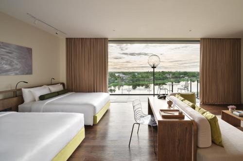 佛统neera retreat hotel的酒店客房设有两张床和大窗户。