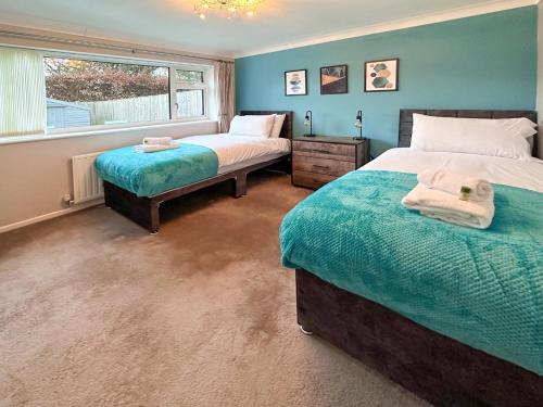 史云顿BLUNSDON LODGE - Spacious Bungalow, High Speed Wi-Fi, Free Private Parking, Garden的一间卧室设有两张床和窗户。