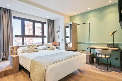 巴塞罗那维亚奥古斯塔酒店的一间卧室配有一张床、一张书桌和一个窗户。