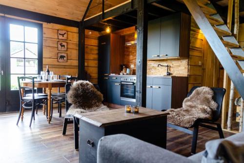 AttreLa cabane du cerf et son sauna的厨房以及带桌椅的用餐室。