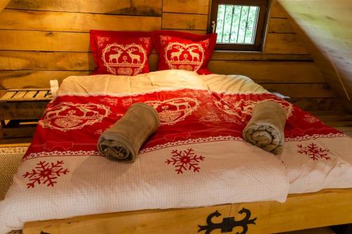 AttreLa cabane du cerf et son sauna的一张带红白毯子和枕头的床