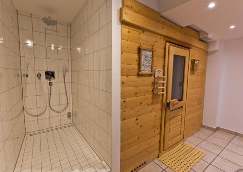 科隆Astor & Aparthotel的带淋浴的浴室和木门。