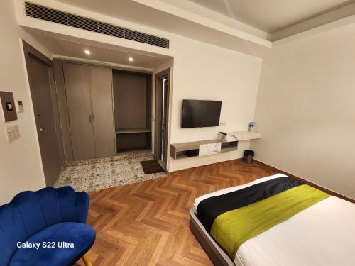 古尔冈Square9 - A Boutique Hotel的一间卧室配有一张床、一台电视和一张沙发