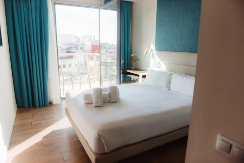 巴塞罗那Arya Stadium Hotel的一间卧室配有一张床,上面有两条毛巾