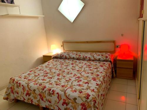 普林希匹纳马尔Rio Piccolo Apartment的一间卧室,配有一张床和一张桌子上的红色物体