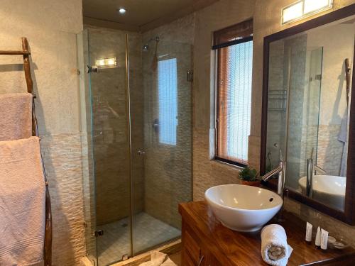 马布拉Luna Piena 19A Zebula golf course and spa resort的一间带玻璃淋浴和水槽的浴室