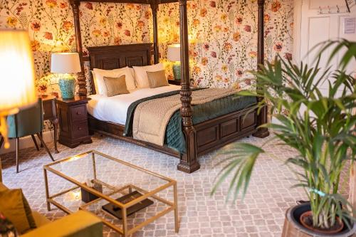 Edzell格兰纳斯克酒店的一间卧室配有天蓬床和盆栽植物