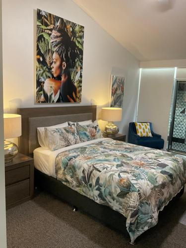 科夫斯港Private Suite Nautilus Beach Front Resort的卧室配有一张床,墙上挂有绘画作品