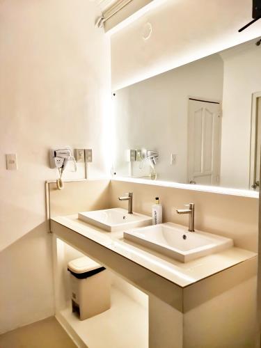 马尼拉NomadsMNL Hostel的一间带两个盥洗盆和大镜子的浴室