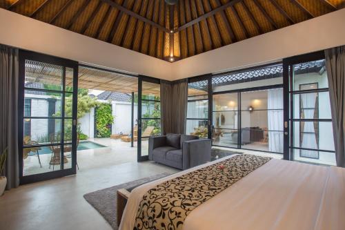 塞米亚克The Kon's Villa Bali Seminyak的一间卧室配有一张大床和一张沙发