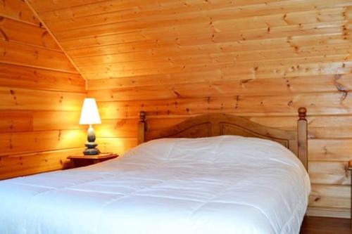 德沃吕伊Grand chalet en bois avec vue splendide的卧室配有一张白色的木墙床
