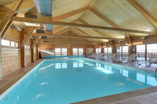德沃吕伊Grand chalet en bois avec vue splendide的一座带木制天花板的大型室内游泳池