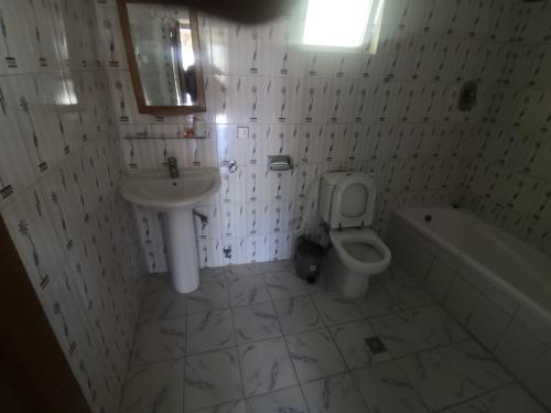 拉利贝拉拉利贝拉酒店的浴室配有盥洗盆、卫生间和浴缸。