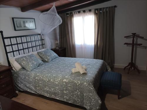 马拉加Casa Rural La ilusion的一间卧室配有一张带蓝色棉被的床