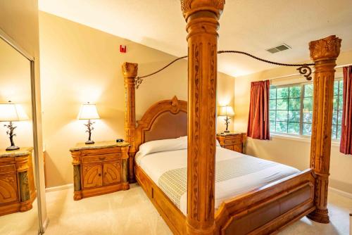 纳什维尔Grand Wood Suites的一间卧室设有木制天蓬床和2个床头柜。