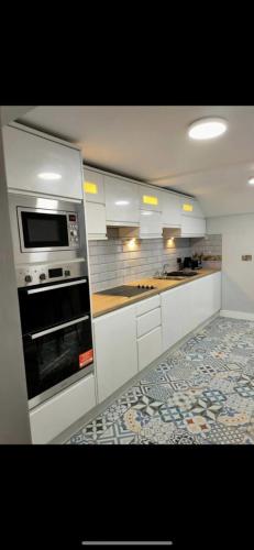 斯凯里斯The Captains Wheel的厨房配有白色橱柜和烤箱。