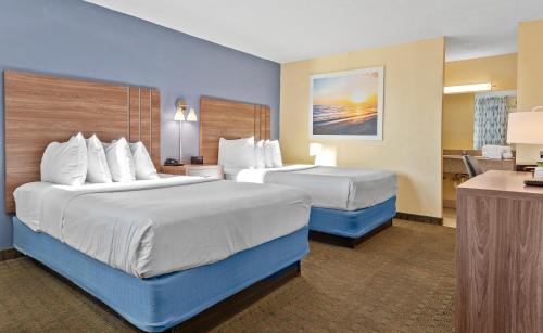 奥兰多Developer Inn Downtown Orlando, a Baymont by Wyndham的酒店客房配有两张床和一张书桌