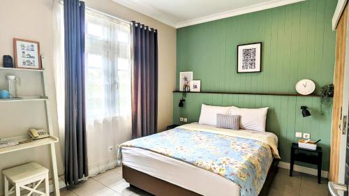 万隆Cottonwood Bed & Breakfast House Bandung的一间卧室设有一张床和绿色的墙壁
