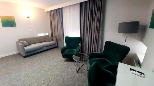 弗罗茨瓦夫Stara Biblioteka的酒店客房设有一间带沙发和椅子的客厅