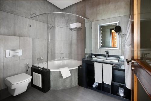 卡萨布兰卡Park Suites Hotel & Spa Luxury Boutique Hotel的带浴缸、卫生间和盥洗盆的浴室