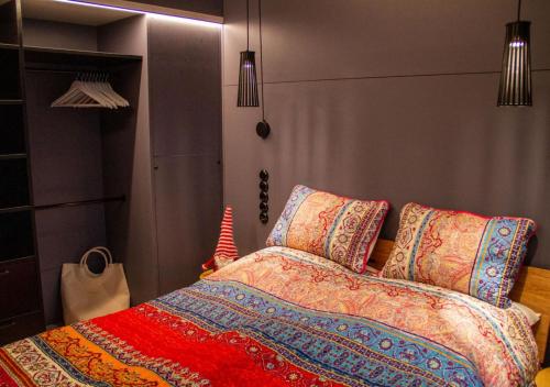 赫尔布兰茨TINY 4 YOU - Ihre stilvollen TINY-Häuser am Bodensee的一间卧室配有一张带色彩缤纷的毯子和枕头的床。