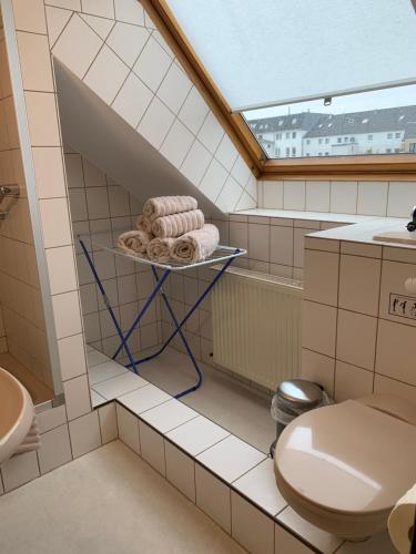 博尔库姆Pension Haus Beckmann的一间带卫生间和架子毛巾的浴室